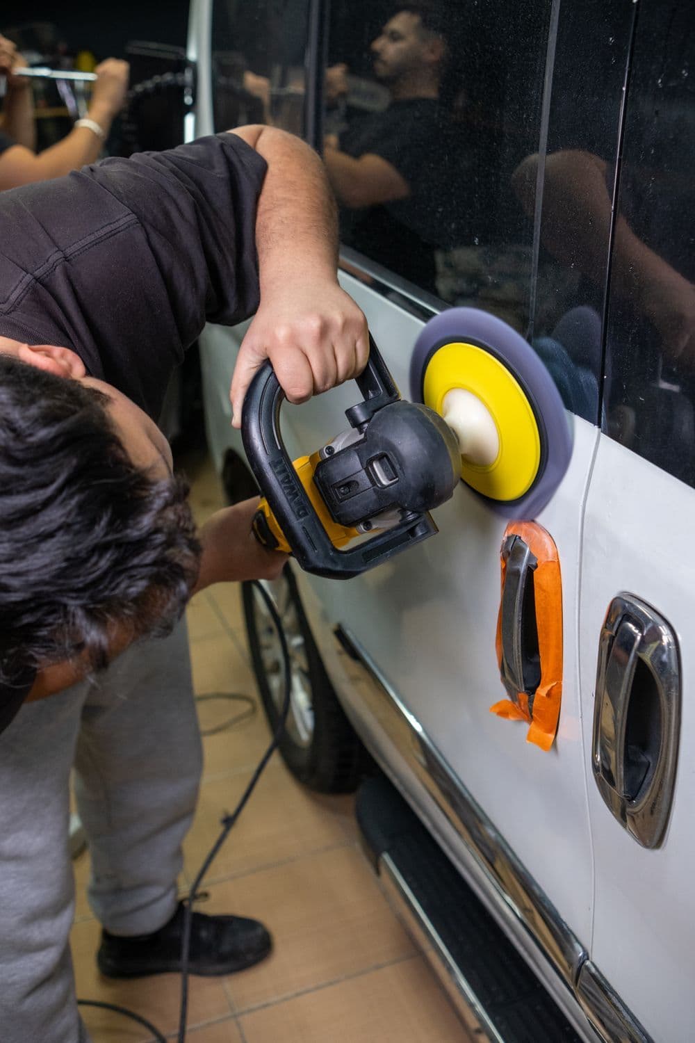 Detailer polijst de lak met een machine polisher