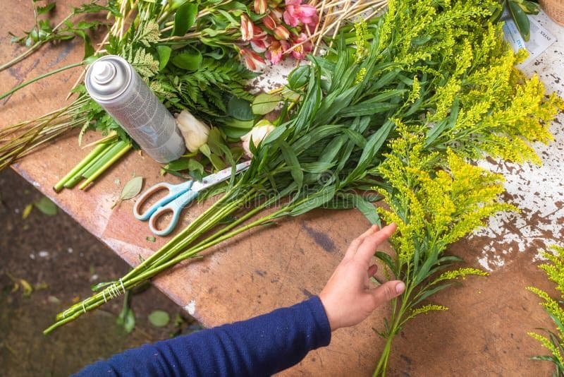 Handen die een boeket schikken bij Atelier Fleur